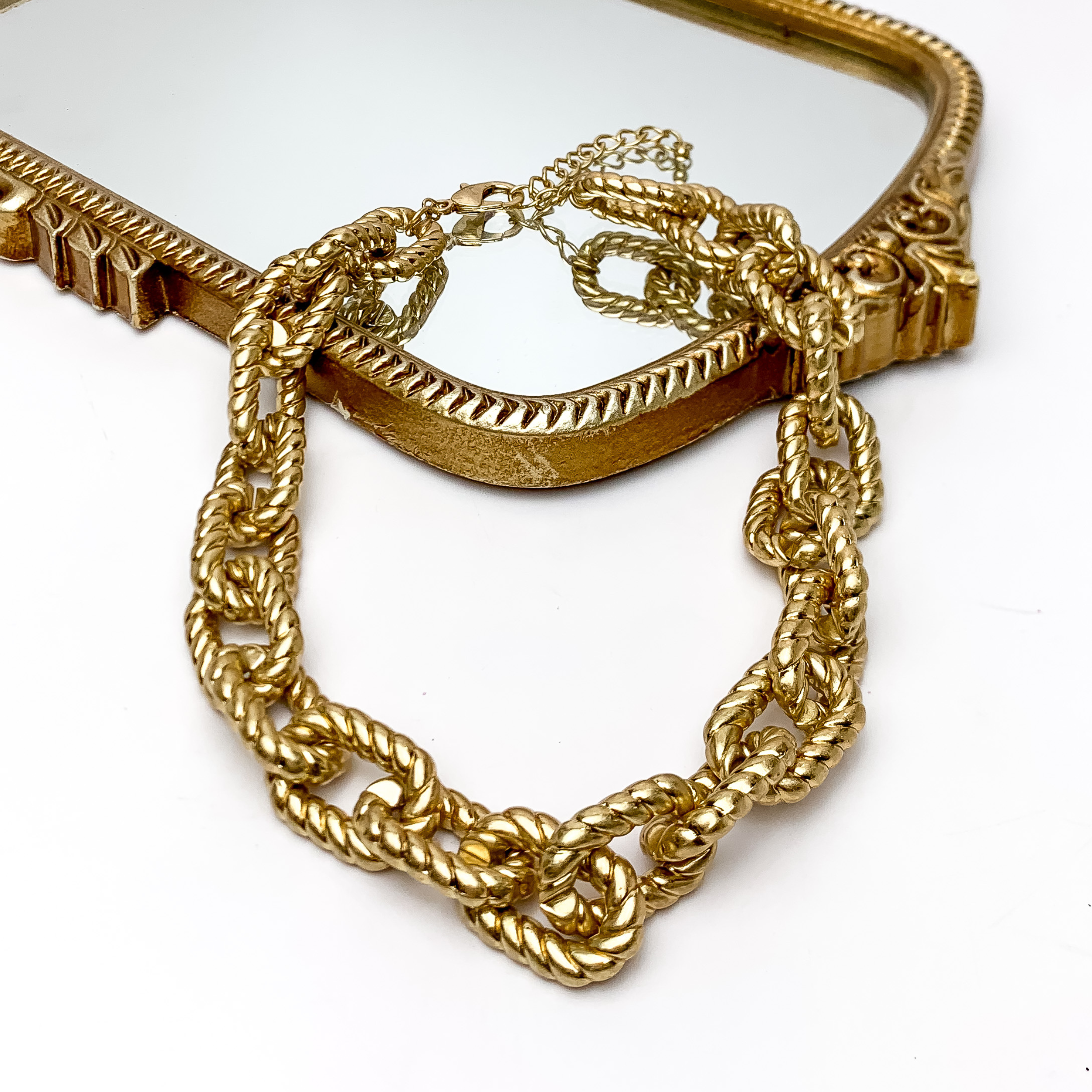Gold Chain No. 3 Necklace. Pictured on a white background with part of the necklace on a gold trimmed mirror.