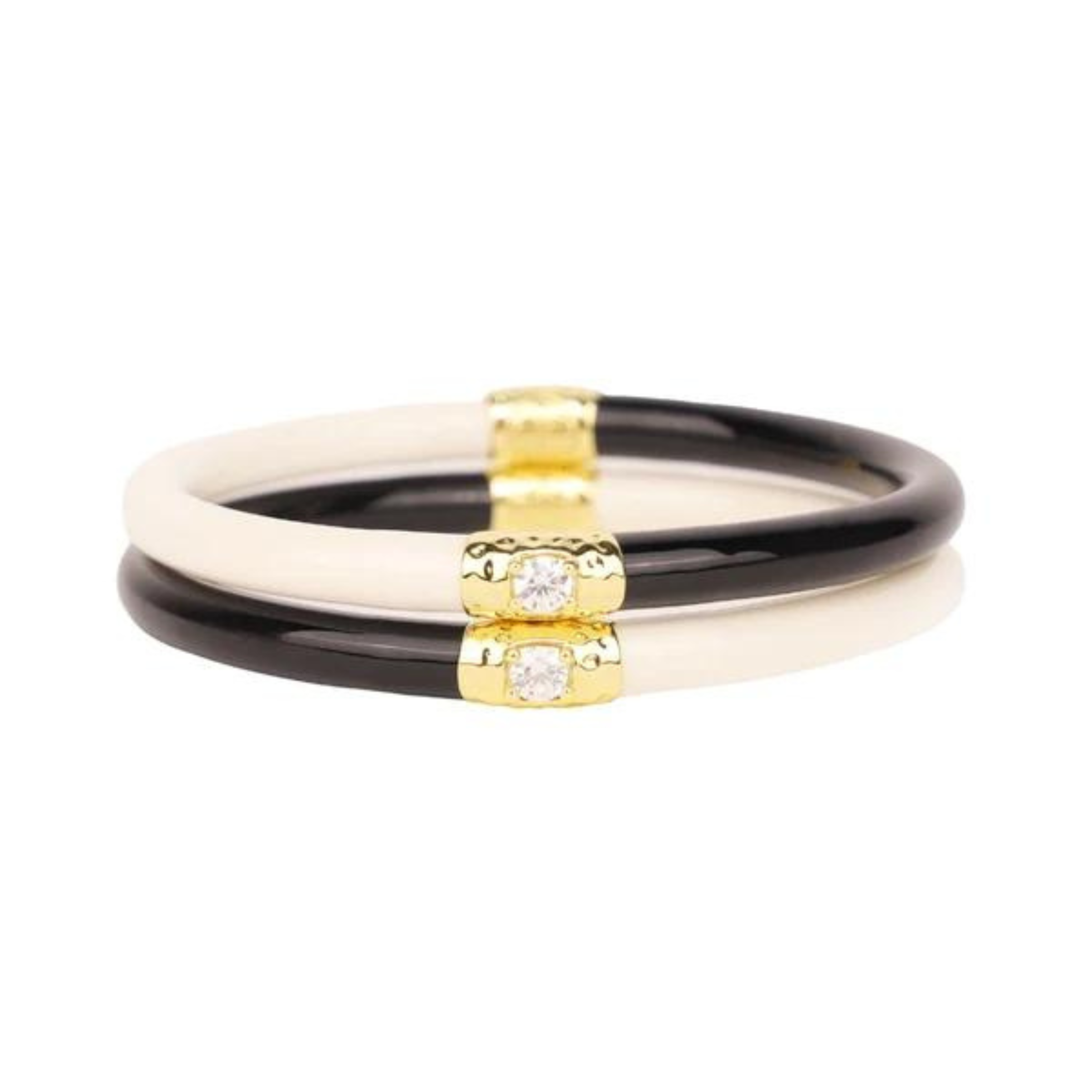 Two half white and haf black plastic, tube bracelet with two gold segments on the bracelet. These bracelets are pictured on top of each other on a white background. 