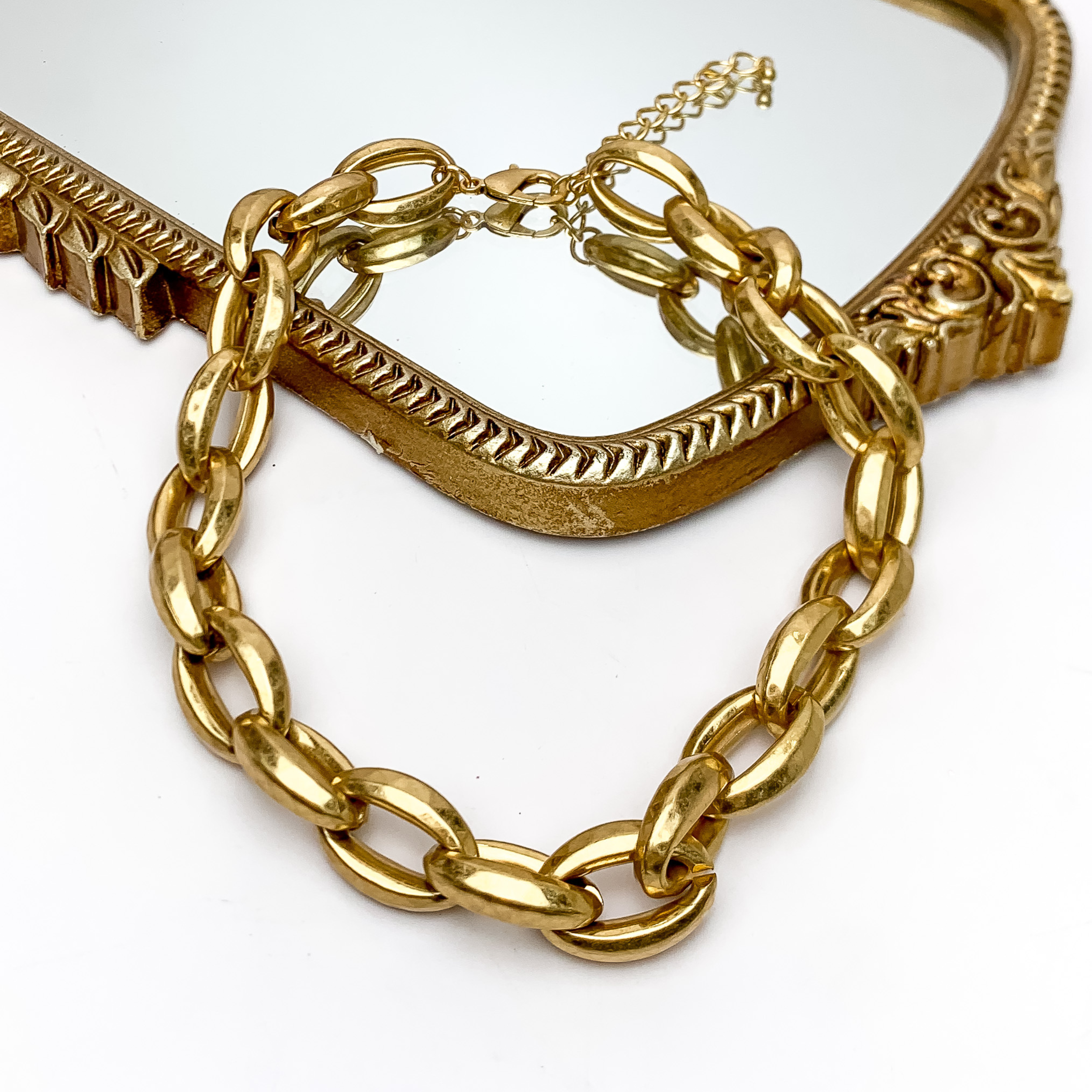 Cute and Classy Chunky Gold Tone Chain Necklace. Pictured on a white background with part of the necklace on a mirror.
