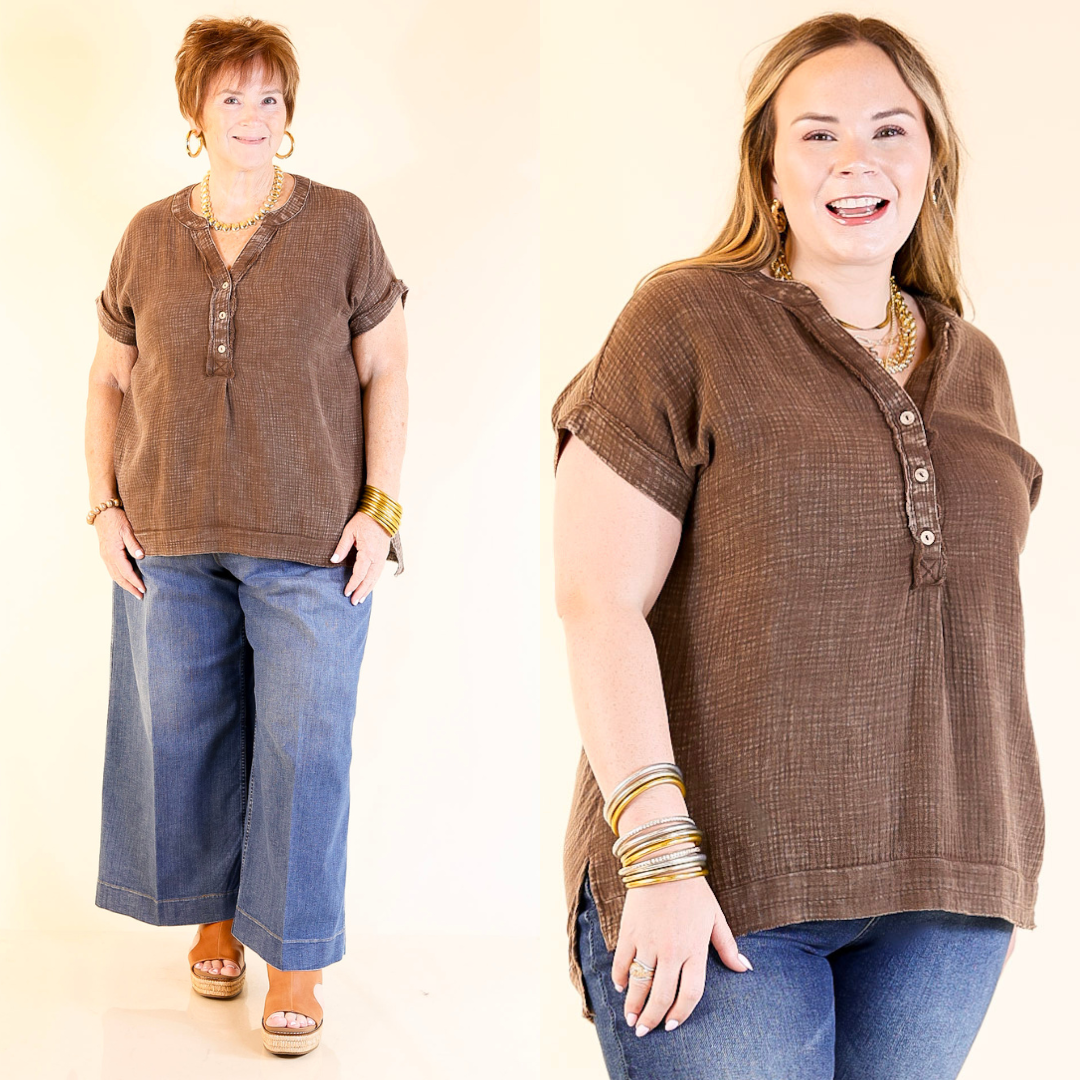 Two women wearing brown short-sleeve shirts and blue jeans against a plain background