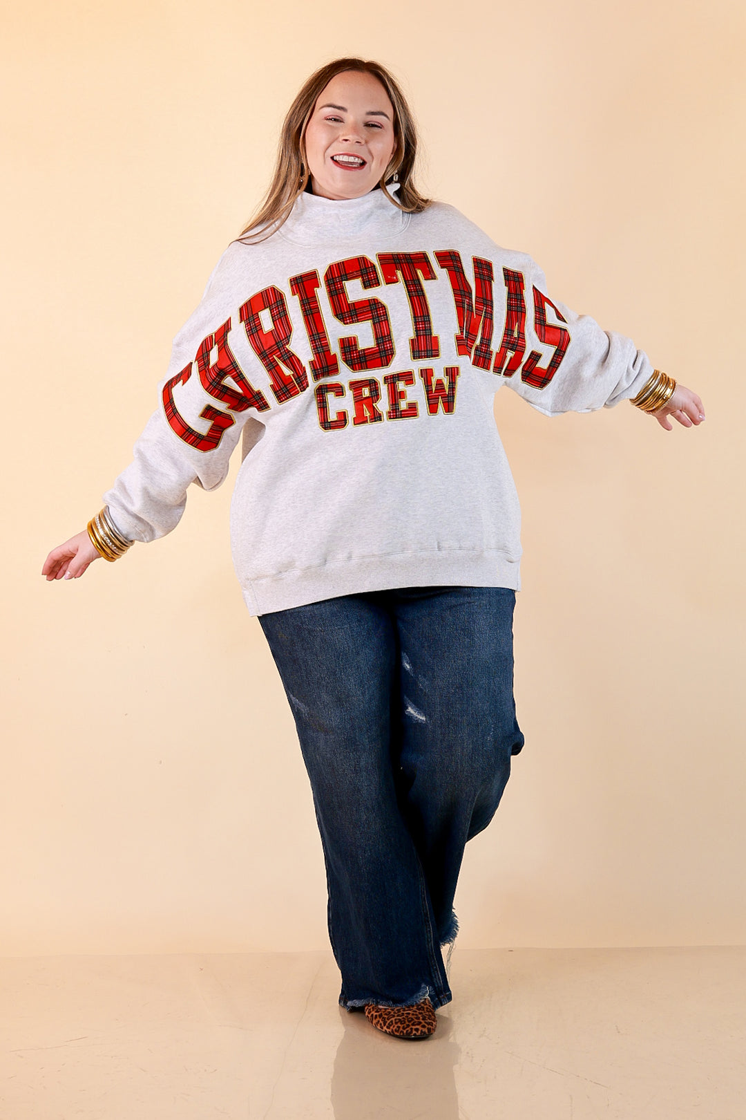 Plaid Tidings heather gray oversized mock neck sweatshirt with red plaid Christmas Crew lettering outlined in gold, styled with dark wash jeans