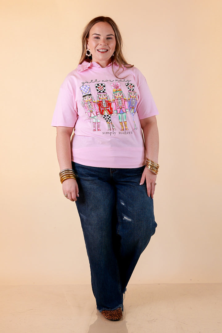 Sugar Plum Squad pink short sleeve nutcracker graphic tee styled with a pink striped collar and dark wash jeans