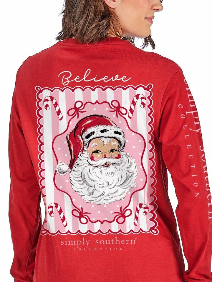 True Believer red long sleeve graphic tee back with a vintage Santa framed in pink stripes, candy canes and bows under Believe script