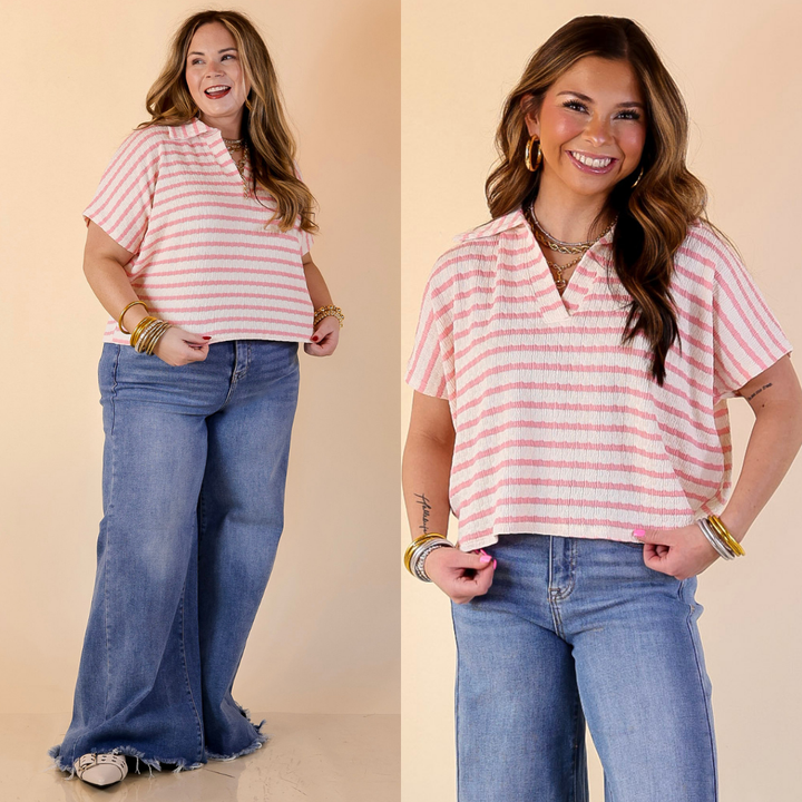 Models are wearing a pink and ivory cropped top and blue jeans on a beige background.