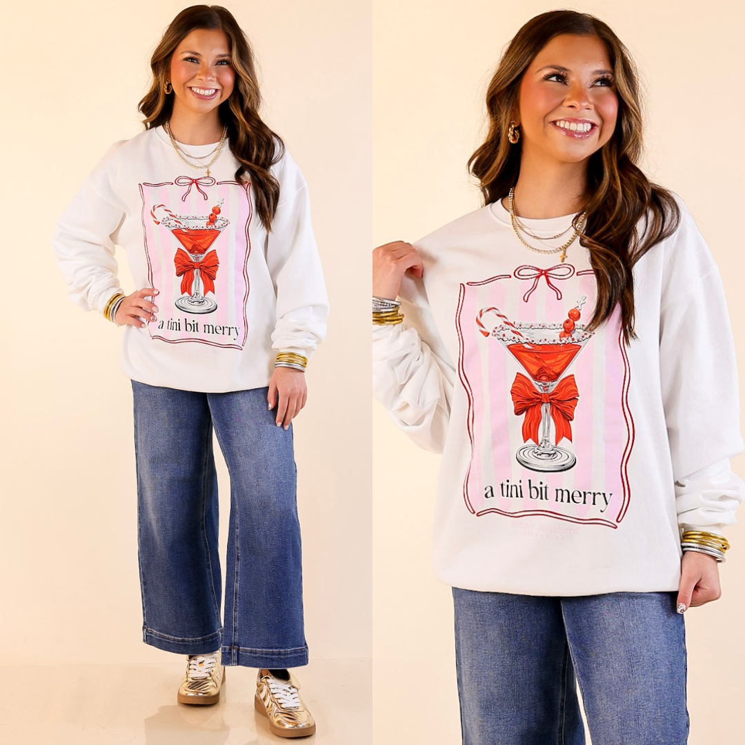 Model is wearing merry martini christmas graphic sweatshirt in white with jeans beige background.