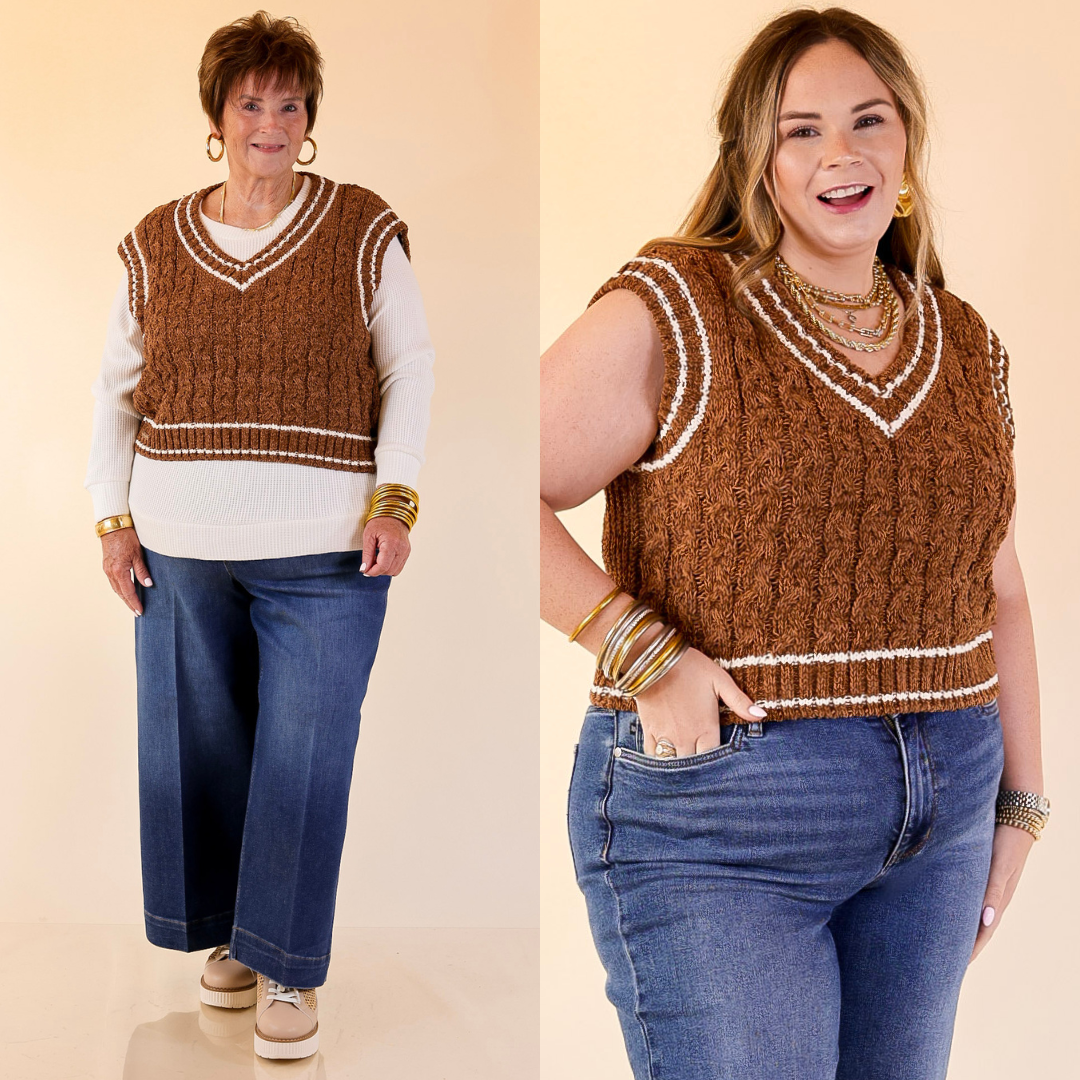 Two women wearing brown knitted vests over white shirts with blue jeans on a beige background.