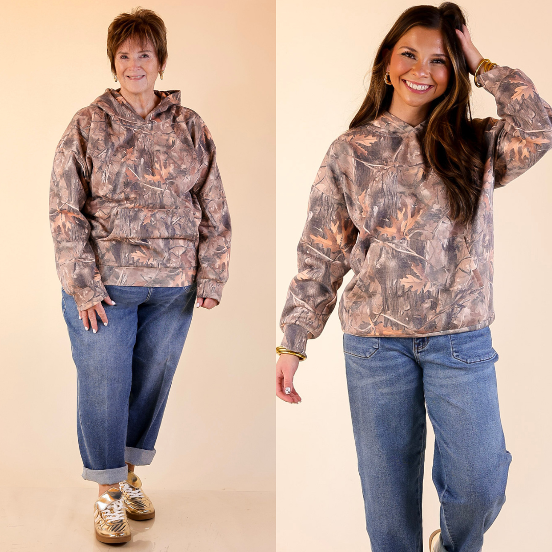 Two people wearing camouflage hoodies and jeans on a beige background