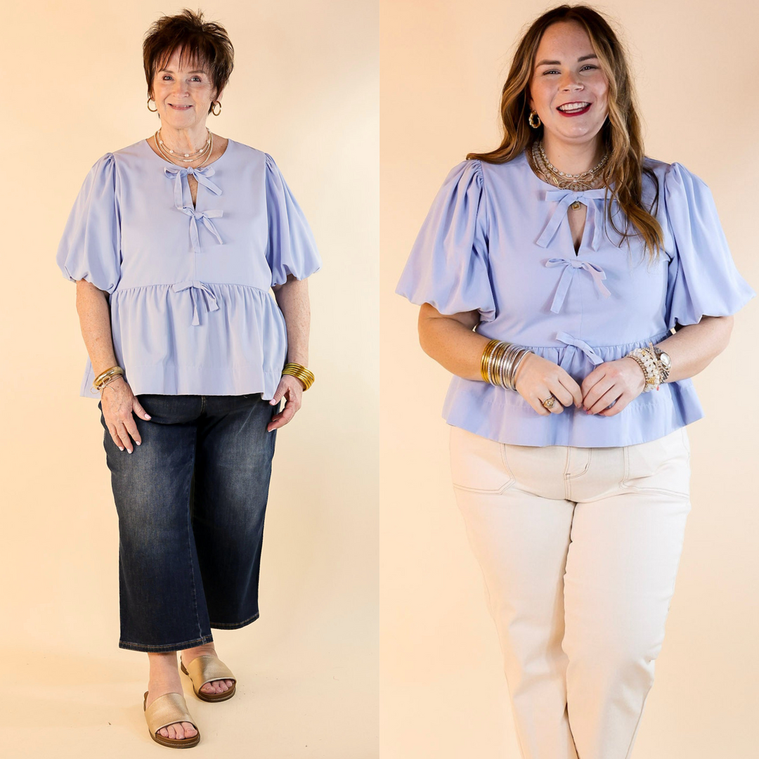 This top features delicate bow tie detailing across the front. The short puff sleeves bring a trendy and feminine flair.