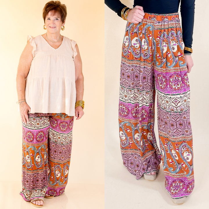 Two people wearing colorful patterned pants on a plain background