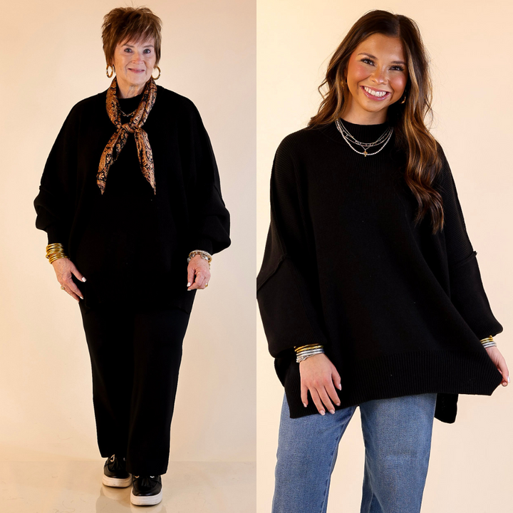 Models are wearing black oversized sweater with side slit. One model is showcasing a smaller size while the other is wearing a larger size.