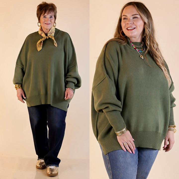 Models are wearing olive green oversized sweater with side slit. One model is showcasing a smaller size while the other is wearing a larger size, with jeans. 