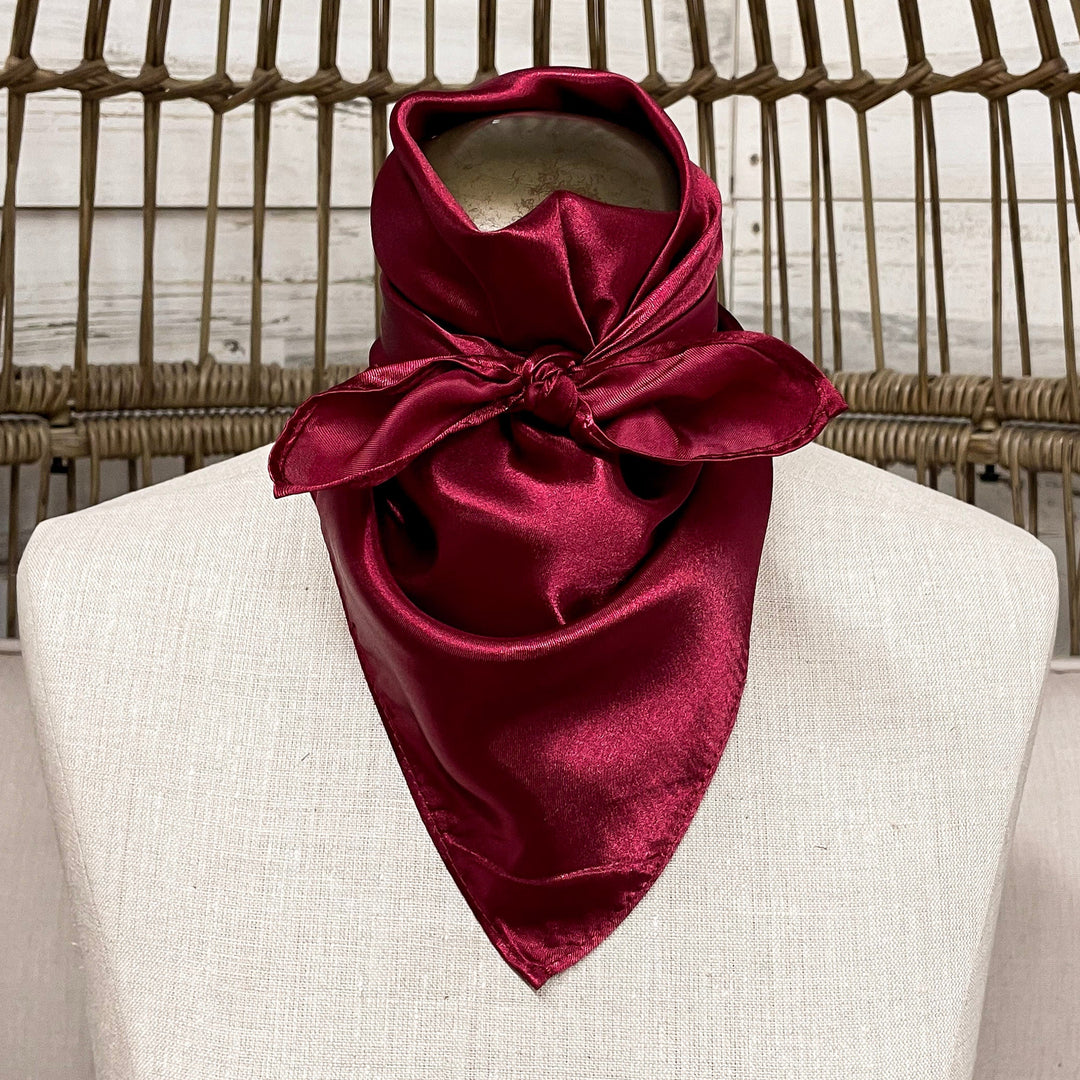 Burgundy scarf on a mannequin head against a wicker background