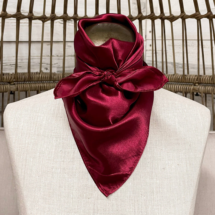 Burgundy scarf on a mannequin head against a wicker background