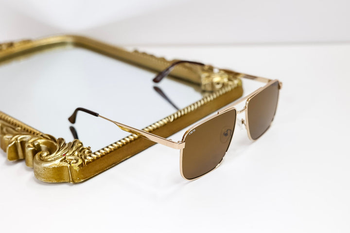 Gold-framed sunglasses on a white background