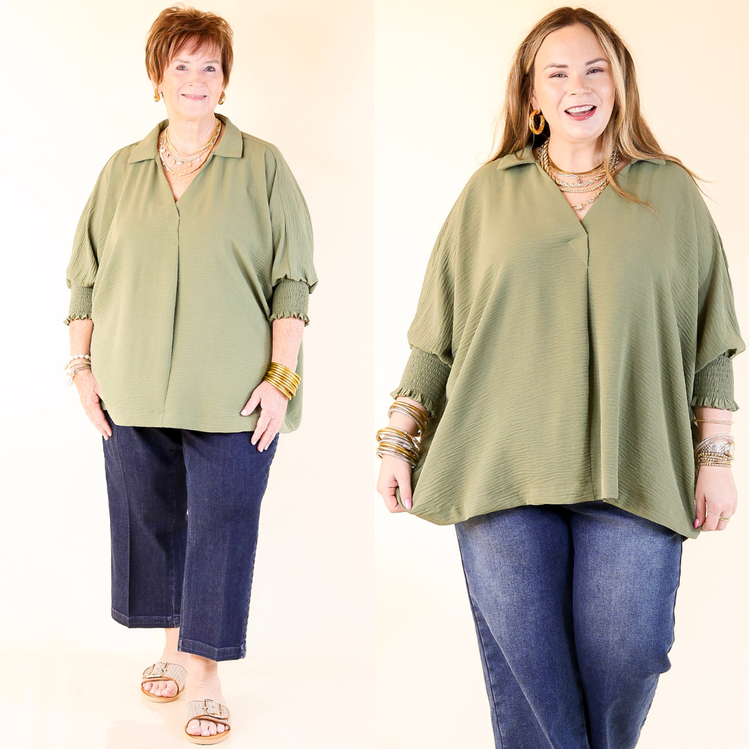 Two women wearing olive green tops and blue jeans on a white background