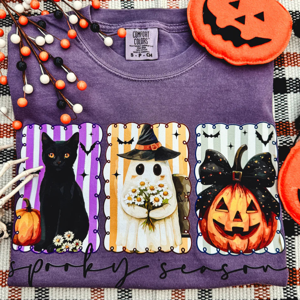 Purple t-shirt with Halloween-themed pocket designs on a plaid background