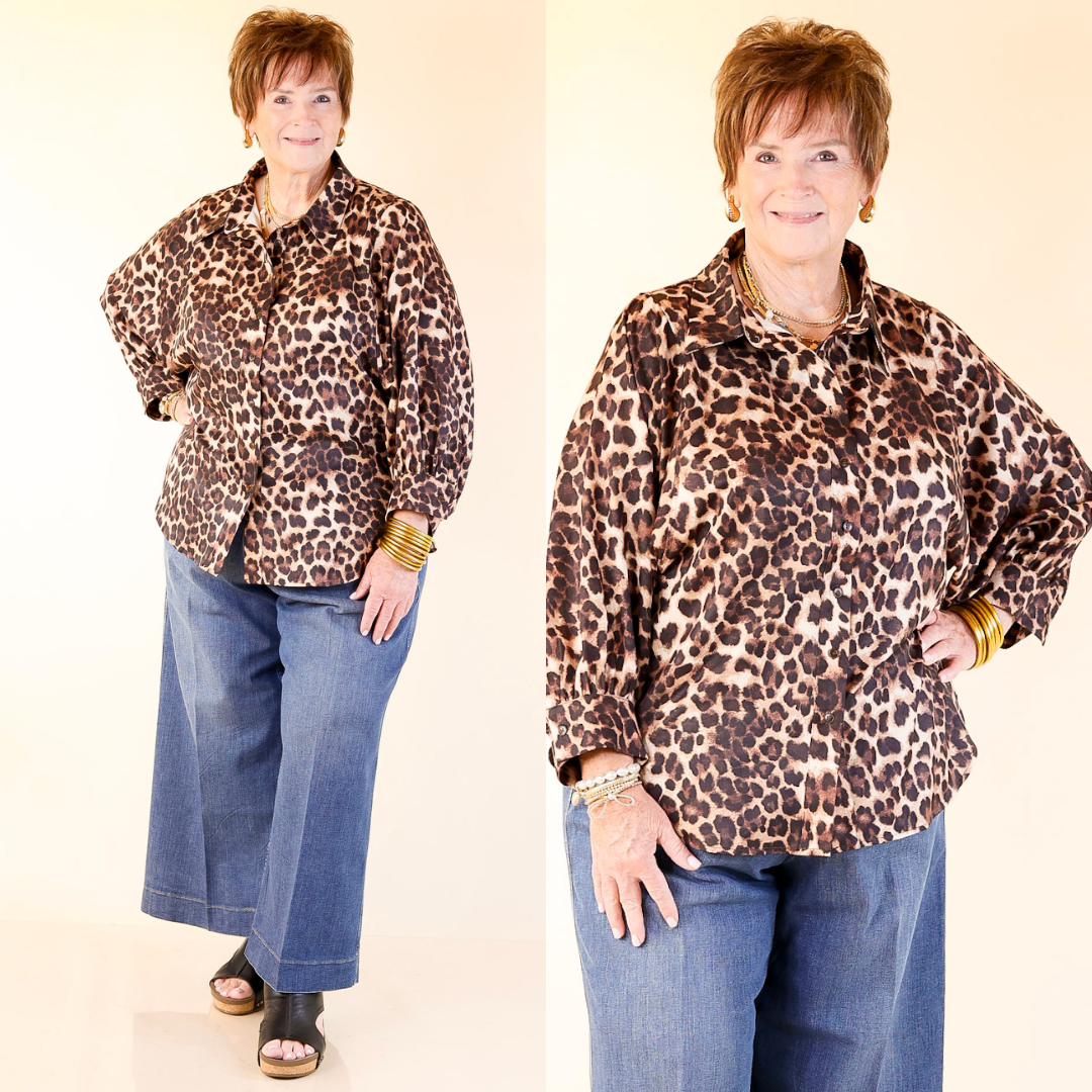 Model wearing a cheetah print blouse and blue jeans on a plain background