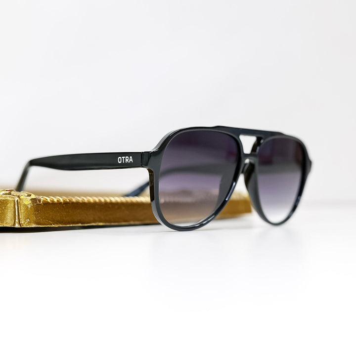 Black sunglasses with gold frame on a white background