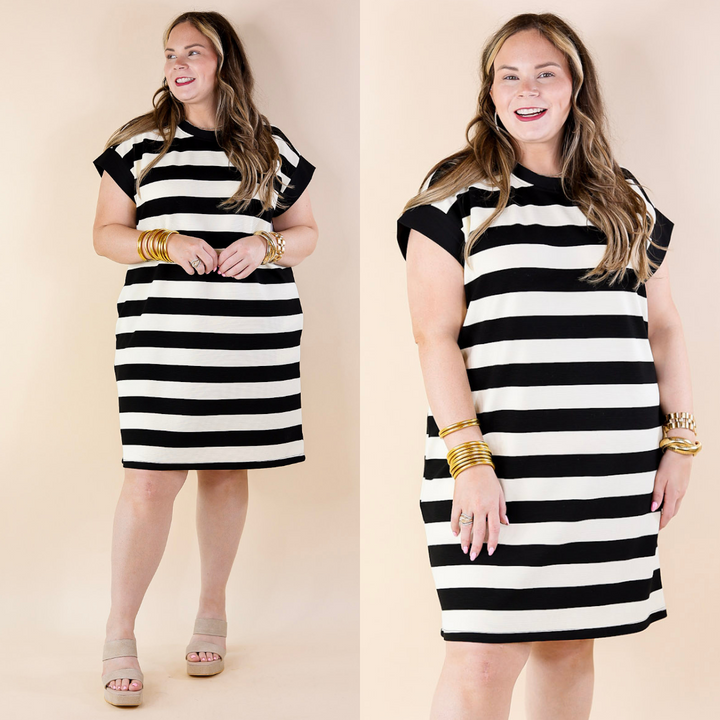 A woman wearing a black and white striped dress on a beige background