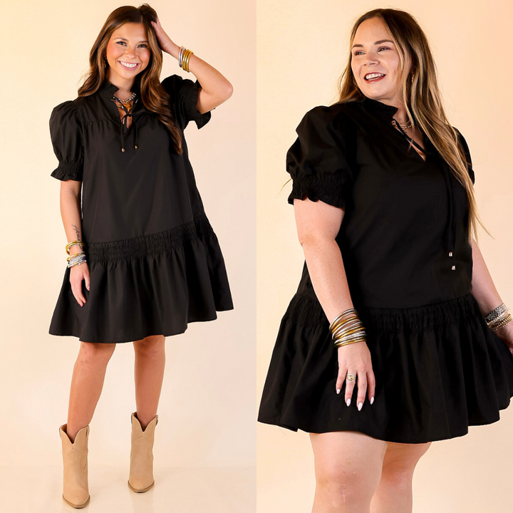 Two women wearing black dresses with puff sleeves on a beige background