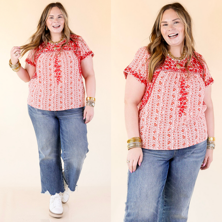 Red floral embroidery across a backdrop of red floral print on an off white background.  Available in sizes small to 3XL.