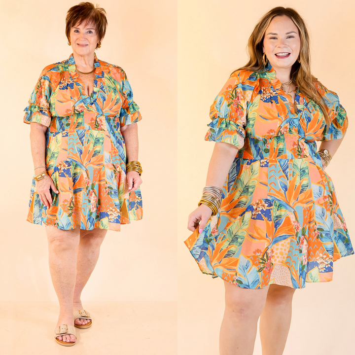 The Sweet as Sundown dress features a vibrant floral print, ruffle puff sleeves, a smocked waist, and a flirty V-neck with a ruffle collar. Sizes small through large.