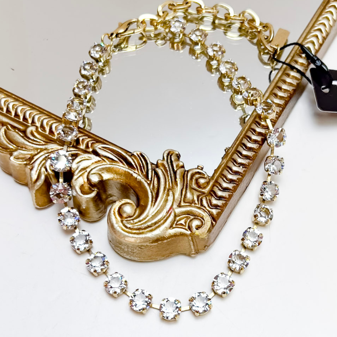 Gold necklace with crystal beads on a white background
