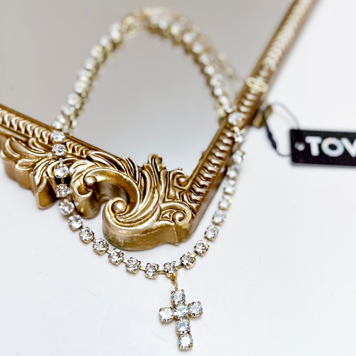 Gold necklace with a cross pendant on a white background
