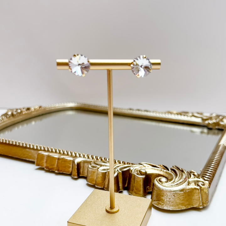 Crystal stud earrings held on a stand.