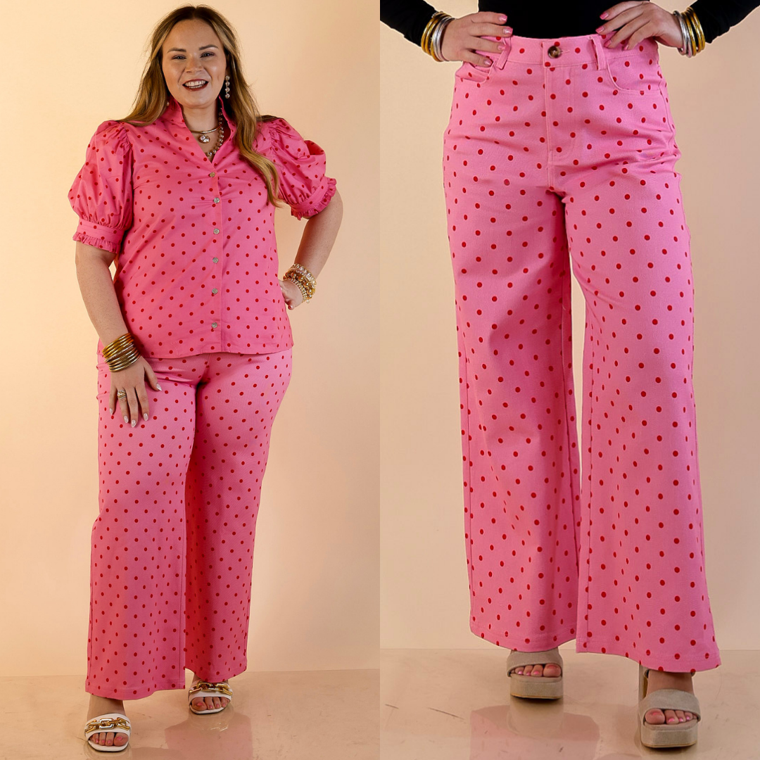 Models are wearing Wide Leg Polka Dot Denim jeans in Pink with Red Dots against a beige backdrop. 
