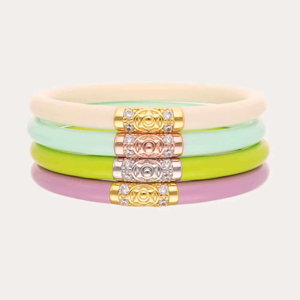 Set of colorful bracelets with decorative beads on a light gray background