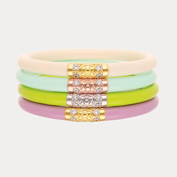 Set of colorful bracelets with decorative beads on a light gray background