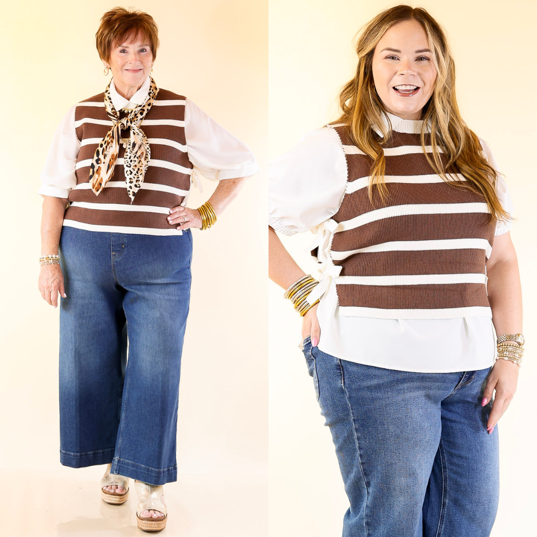 Two women wearing matching brown and white striped tops with blue jeans on a beige background