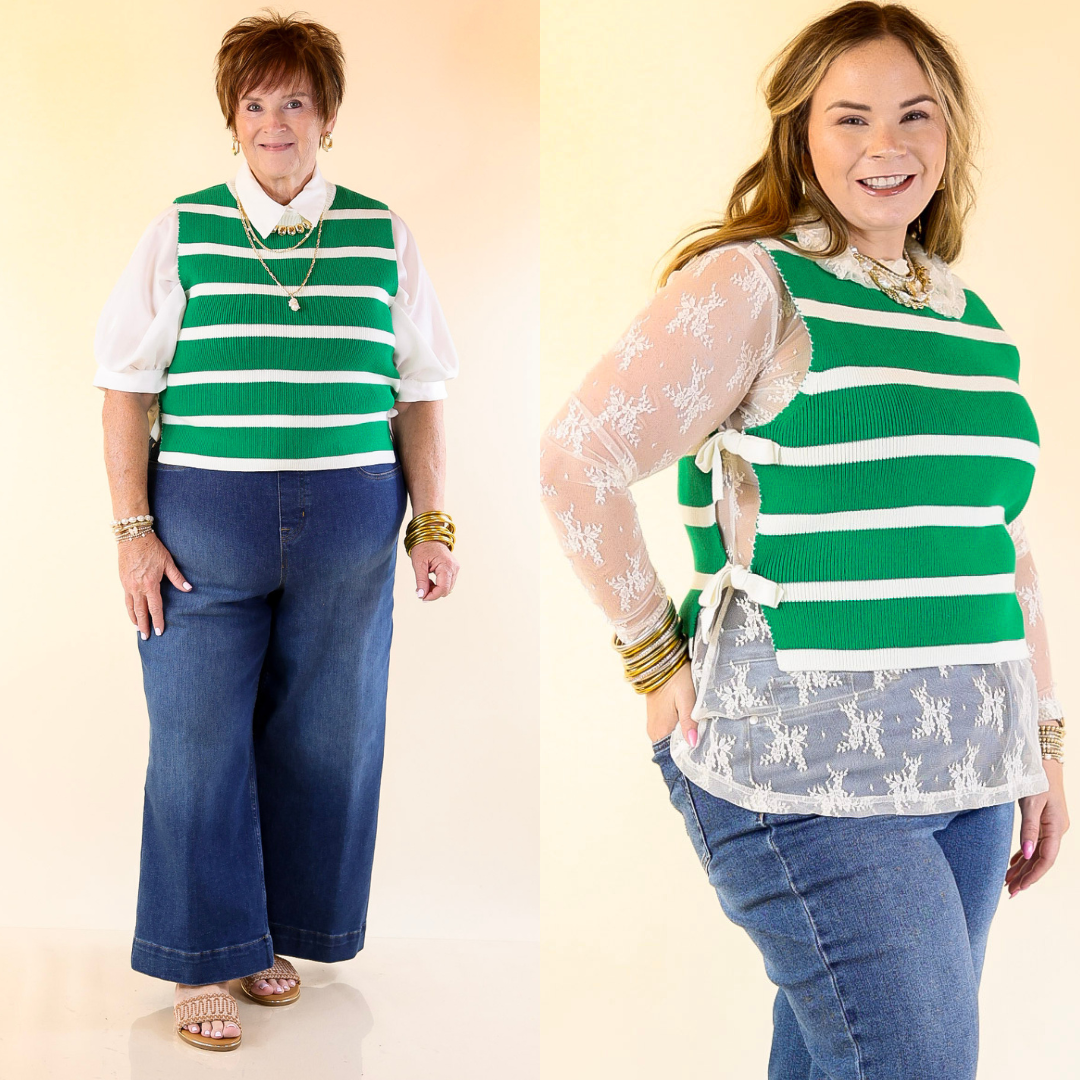 Two women wearing green and white striped tops with blue jeans on a plain background