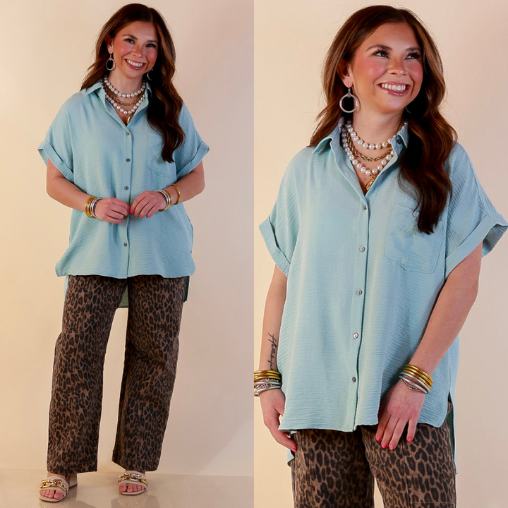 Model is wearing Collared Button Up Top in Muted Aqua Blue with Jeans against a beige backdrop. 