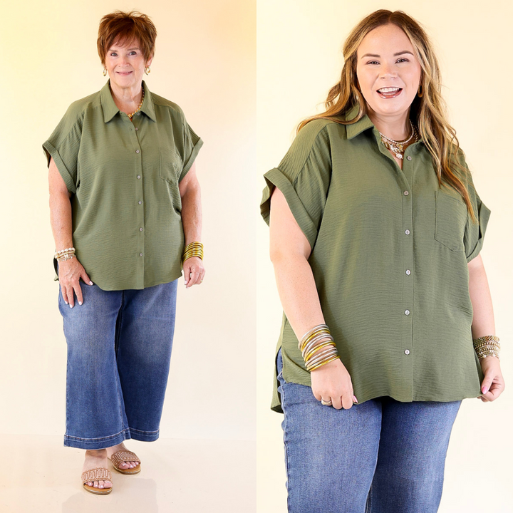 Two women wearing olive green button-up shirts and blue jeans against a plain background