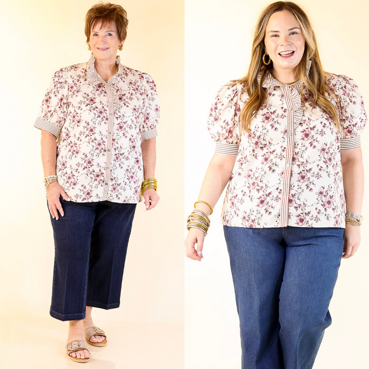 Two women wearing floral tops and blue pants against a beige background