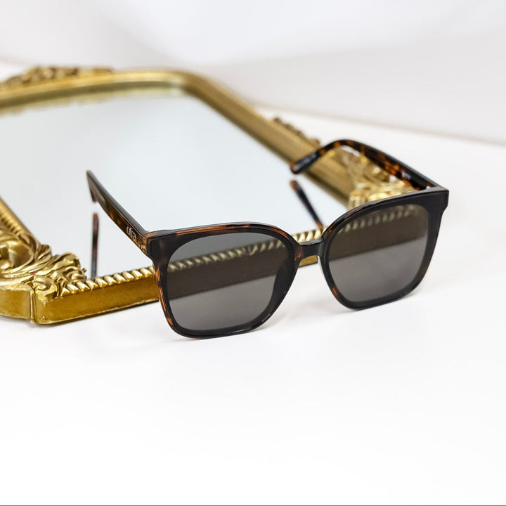 Sunglasses with gold frame on a white surface