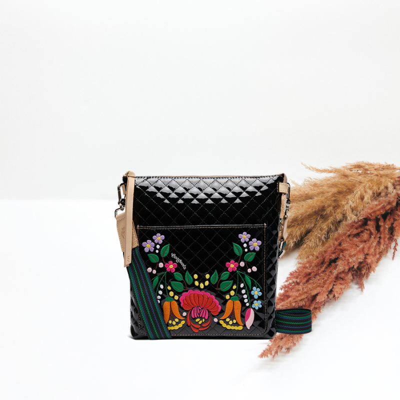 Black quilted handbag with colorful floral embroidery on a white background
