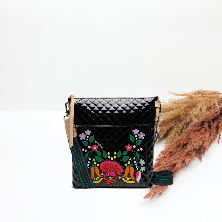 Black quilted handbag with colorful floral embroidery on a white background
