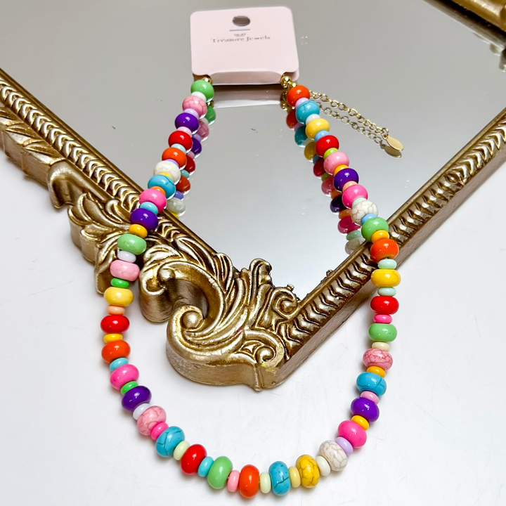 Treasure Jewels multicolor beaded necklace featuring vibrant round and disc beads in bright rainbow colors with gold accents.