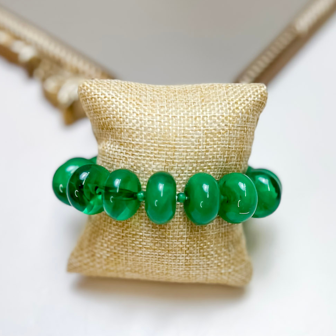 Treasure Jewels stretch bracelet featuring glossy translucent green rounded beads.