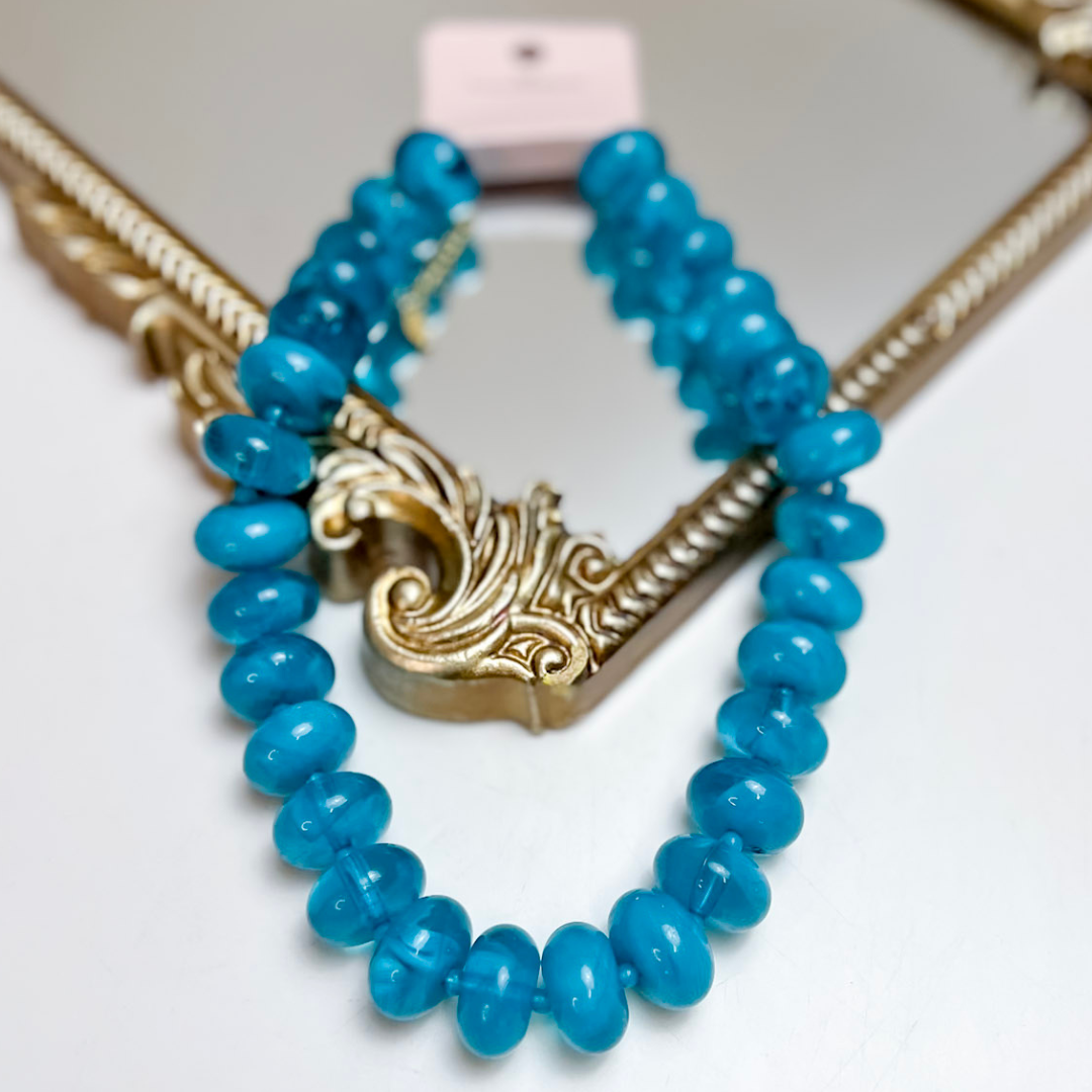 Treasure Jewels aqua blue beaded necklace featuring glossy rounded glass beads with an adjustable gold extender chain.
