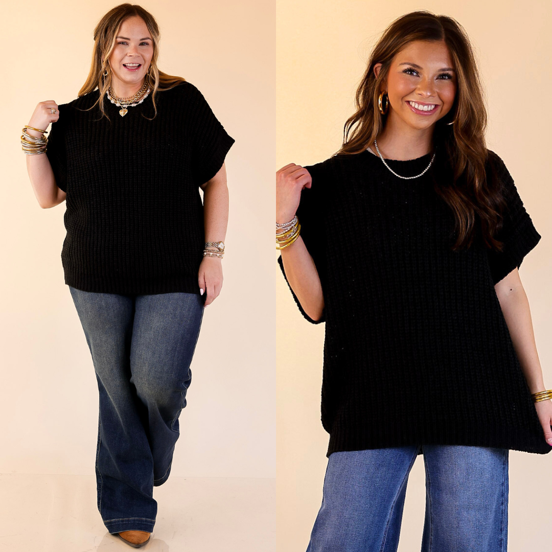 Two women wearing black sweater tops and blue jeans against a beige background