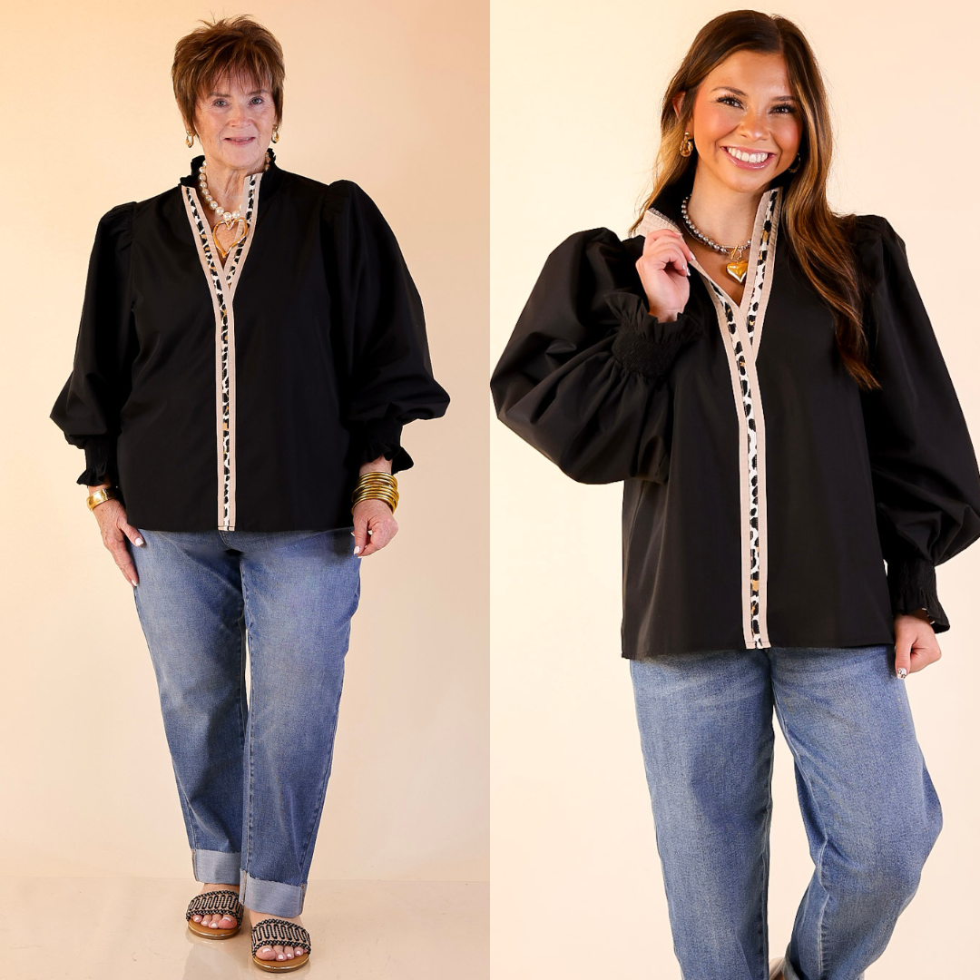 Two women wearing black tops with leopard trim and jeans on a beige background.