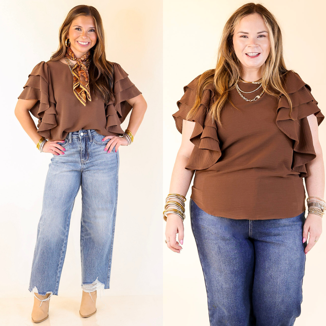 Two women wearing brown ruffled tops and blue jeans on a plain background