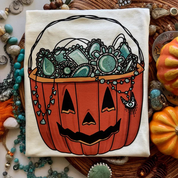 Pumpkin with face design on a white towel surrounded by decorative items