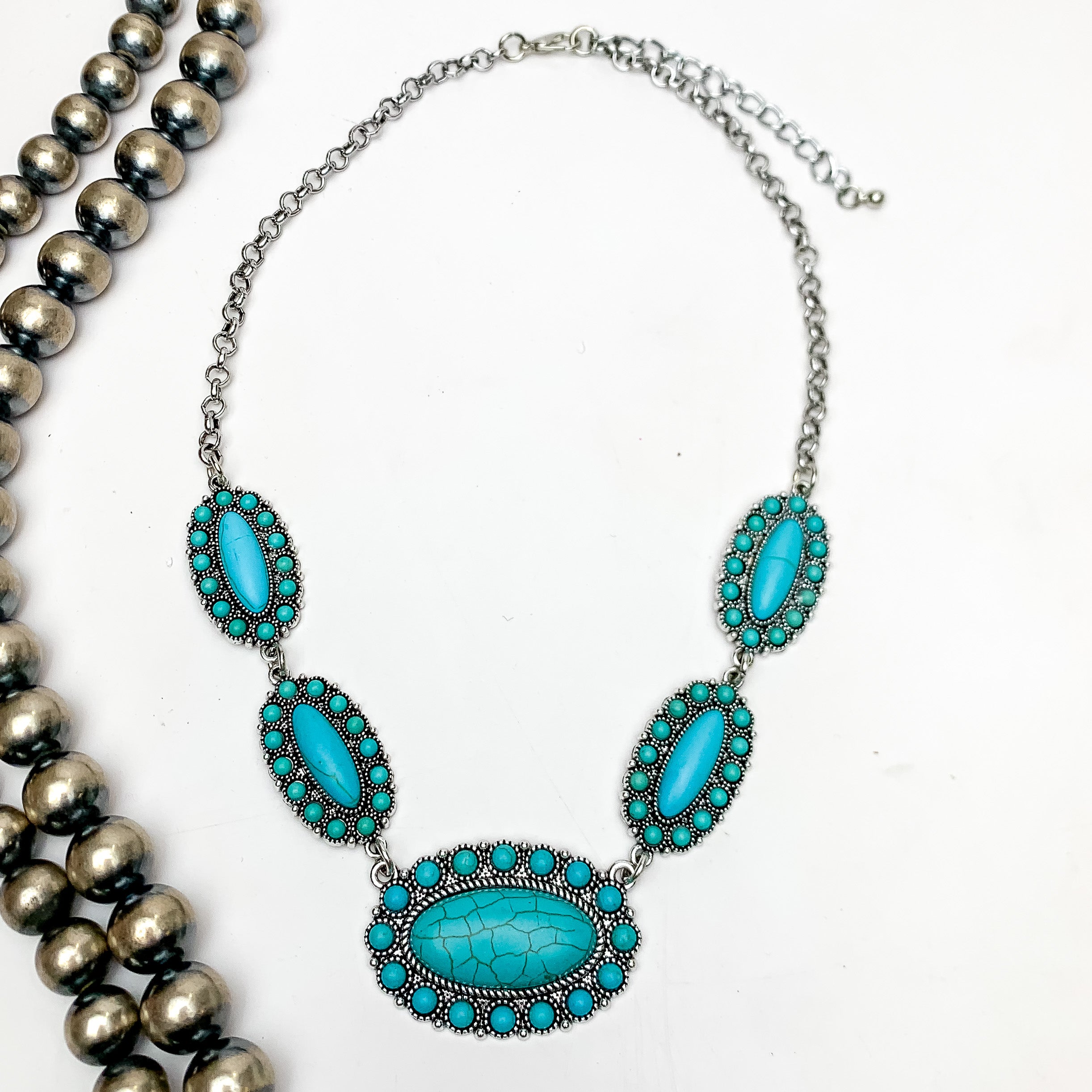 Western Silver Tone Necklace in turquoise blue. This necklace is on a white background with Navajo pearls on the left.