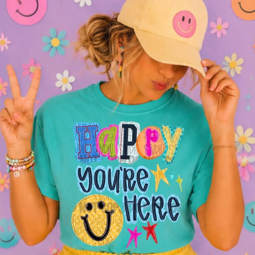 Turquoise blue teacher graphic tee featuring colorful patchwork lettering, smiley face, stars, and the phrase "Happy You&