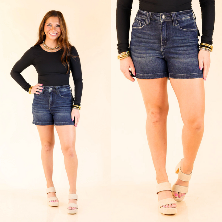 Uptown Blues are dark wash denim shorts with back flap pockets and a polished, flattering fit—easy to dress up or down.